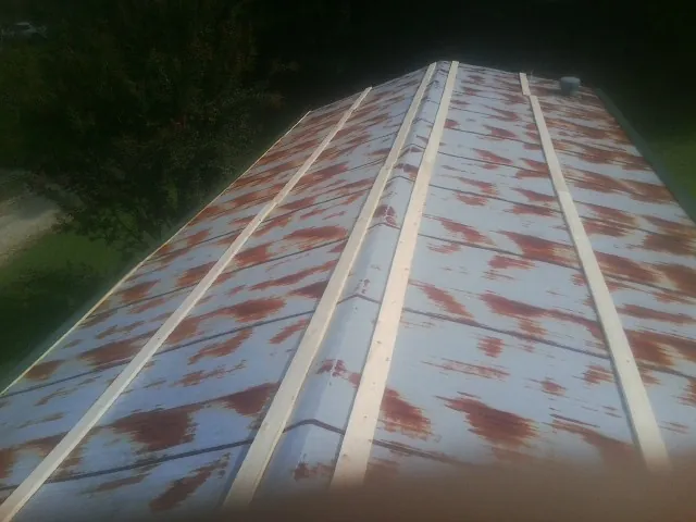 Rusted metal roof panels with new wood purlins before replacement — Storm Damage Roof Repair in Occoquan by Roofing Brothers